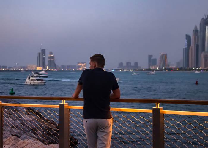 Traveller looking over the Abu Dhabi waterfront at dusk